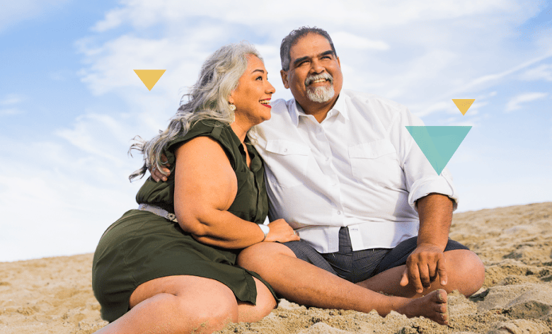 Middle-Aged Couple Sitting in the Sand at the Beach LOKELMA Homepage Banner